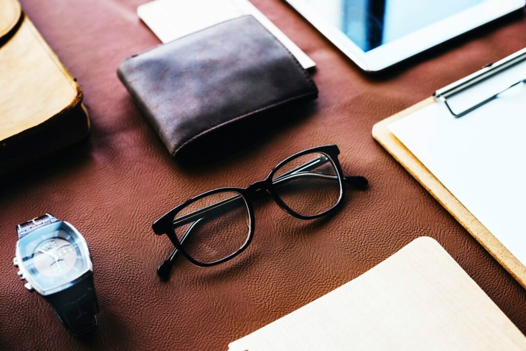 Closeup of eyeglasses and wallet on brown leather background