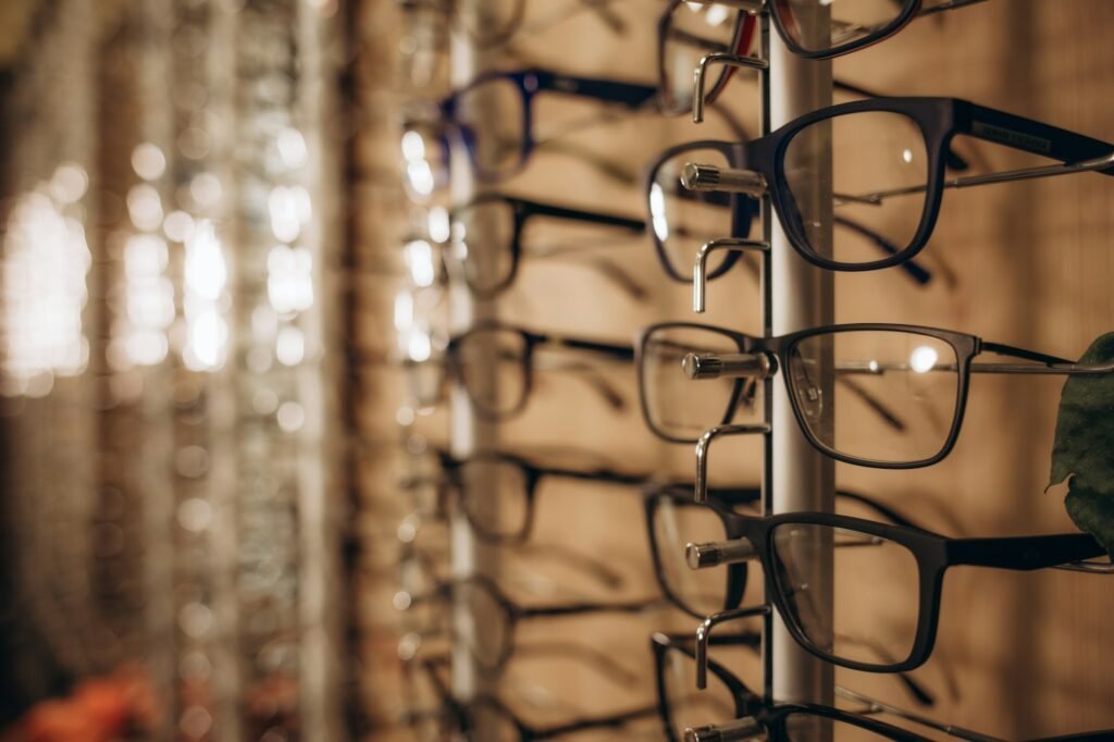 Eyeglasses shop. Stand with glasses in the store of optics. Woman's hand chooses glasses.